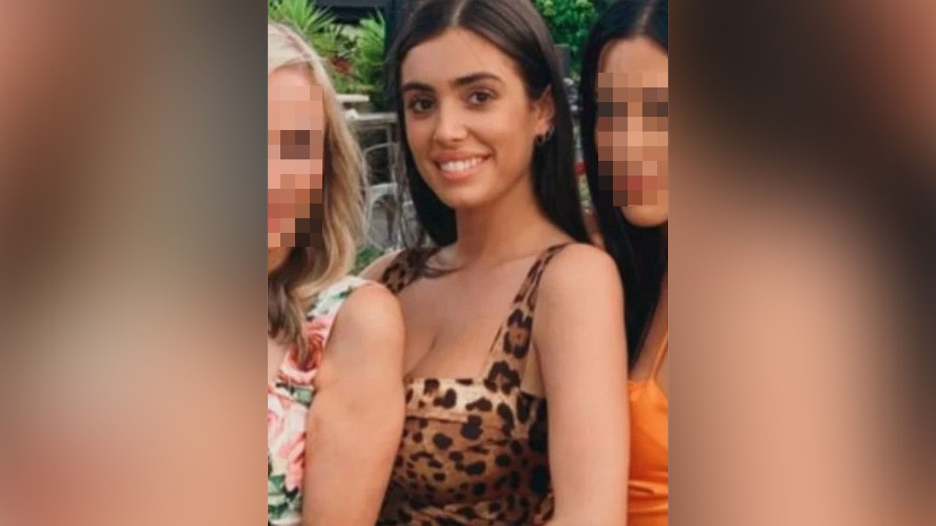 Una chica sonriente con cabello largo y un vestido de leopardo