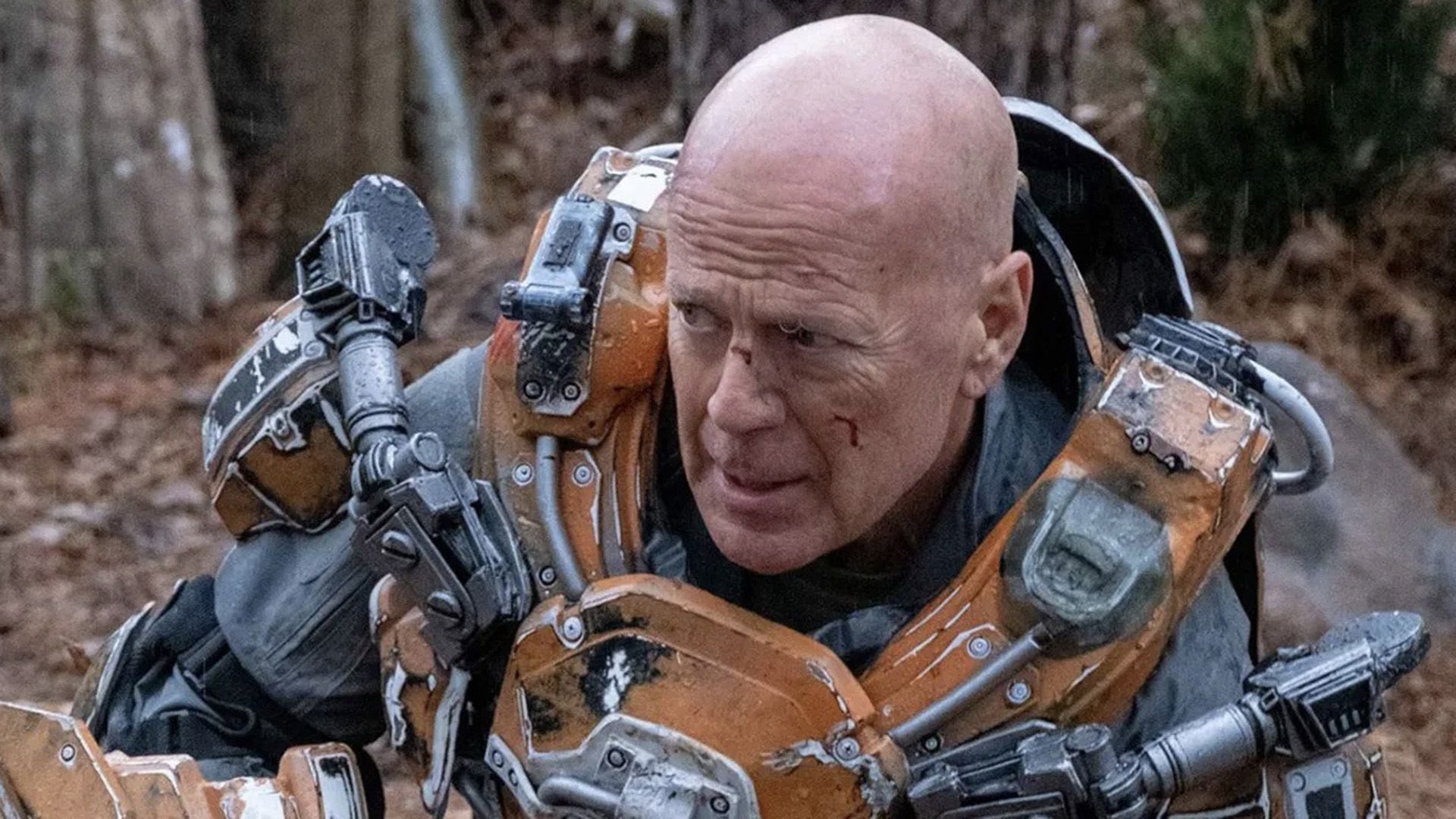 Bruce Willis en armadura fantástica de color gris y naranja en una escena de 'Cosmic Sin'