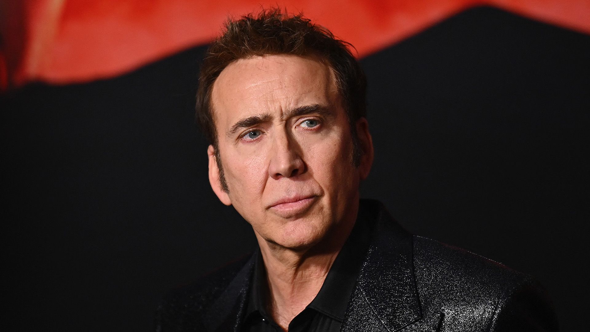 Actor Nicolas Cage on a black and red background