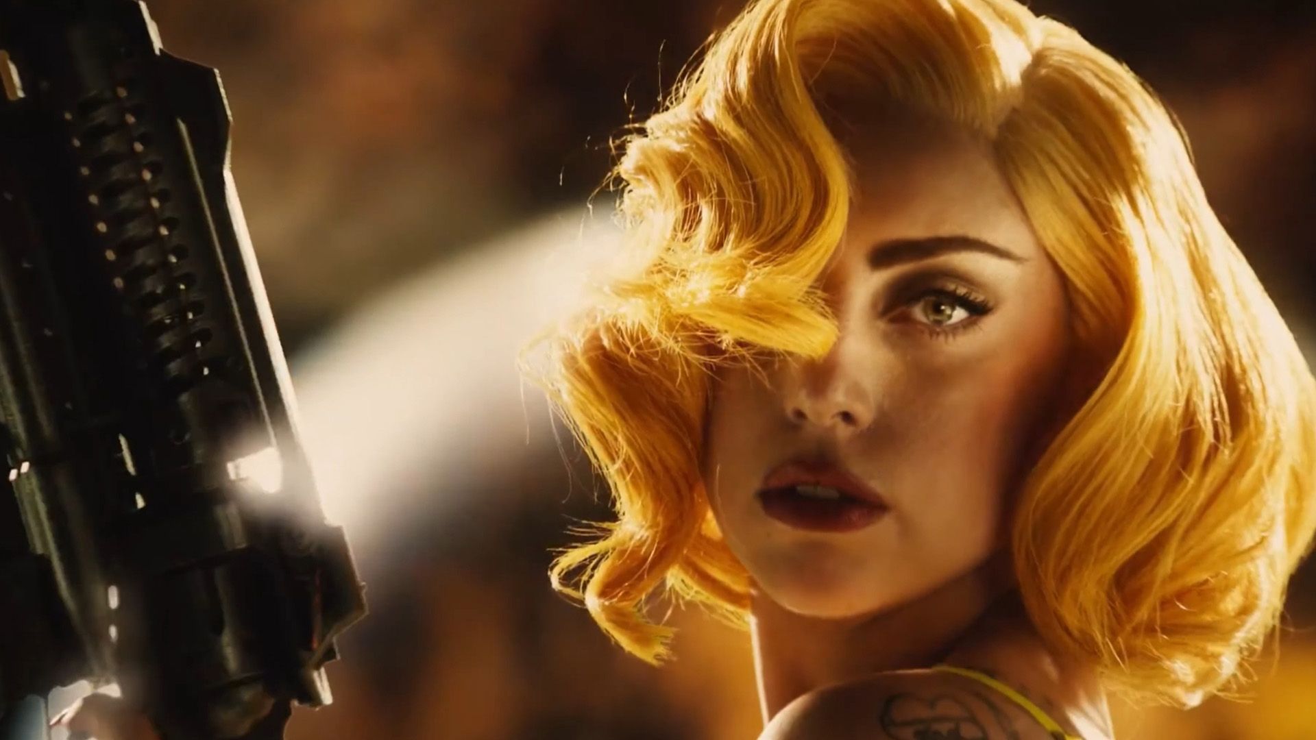 Lady Gaga con cabello rojo y un arma en sus manos