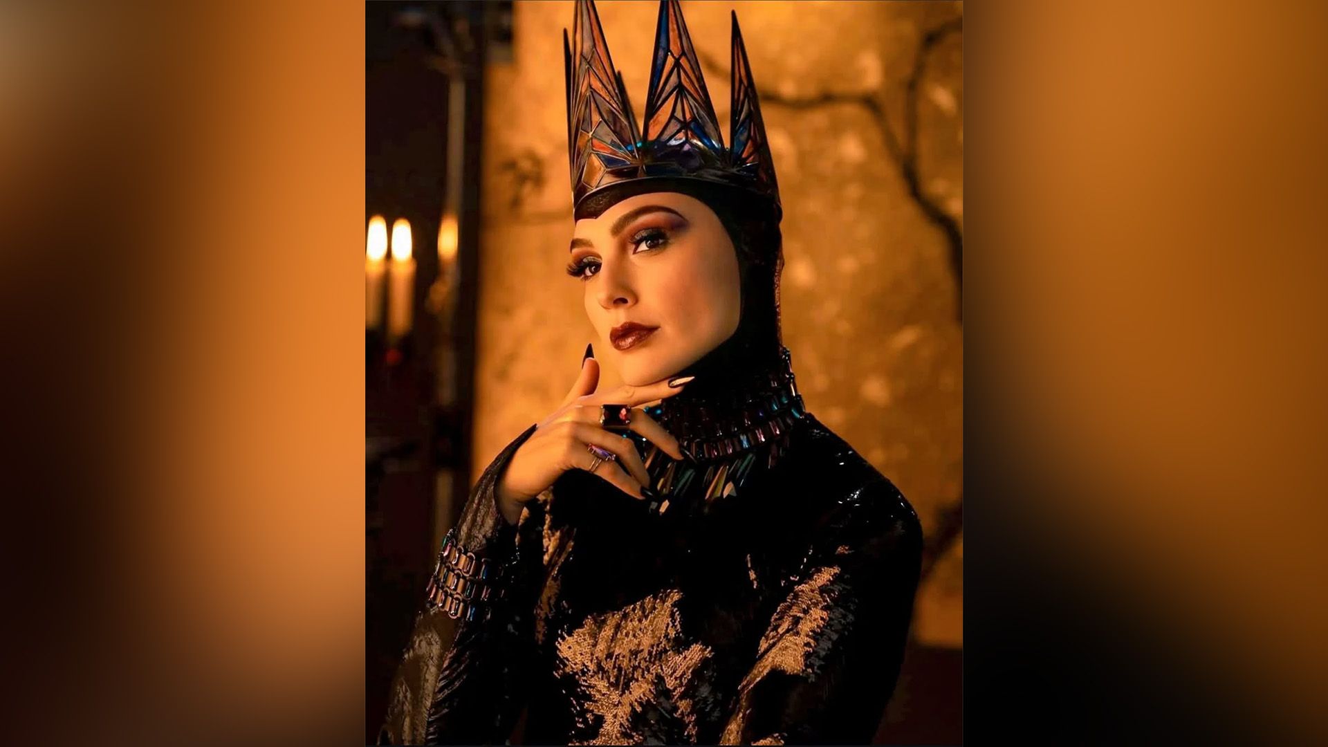 Gal Gadot como la Reina Malvada con un atuendo negro brillante y una corona negra