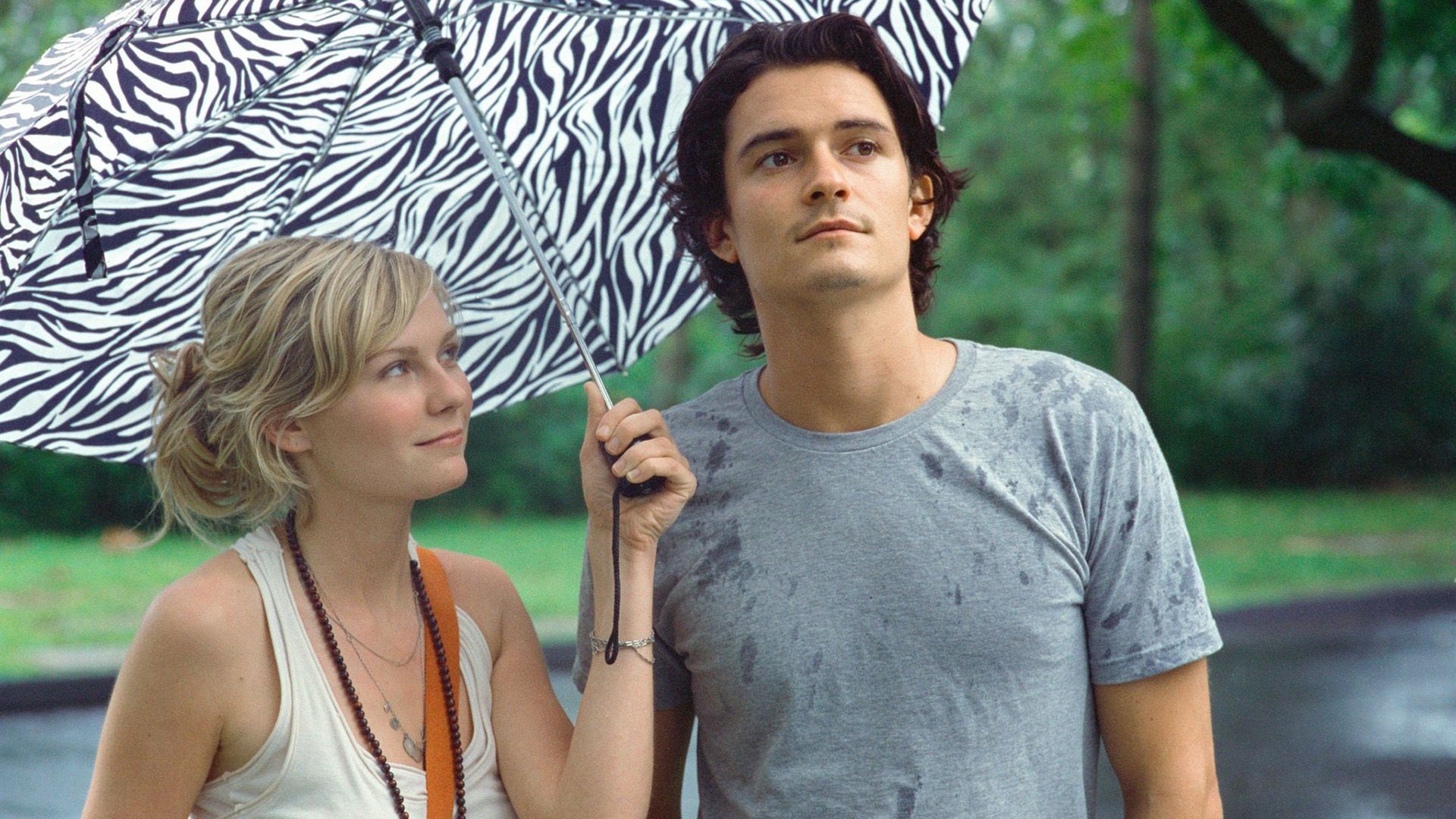 Kirsten Dunst y Orlando Bloom bajo un paraguas con patrón de cebra