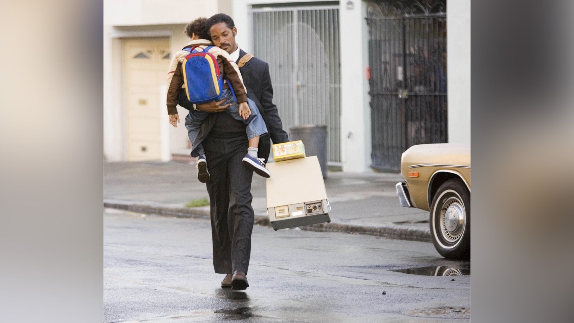 Will Smith caminando por la carretera sosteniendo a su pequeño hijo cerca de él