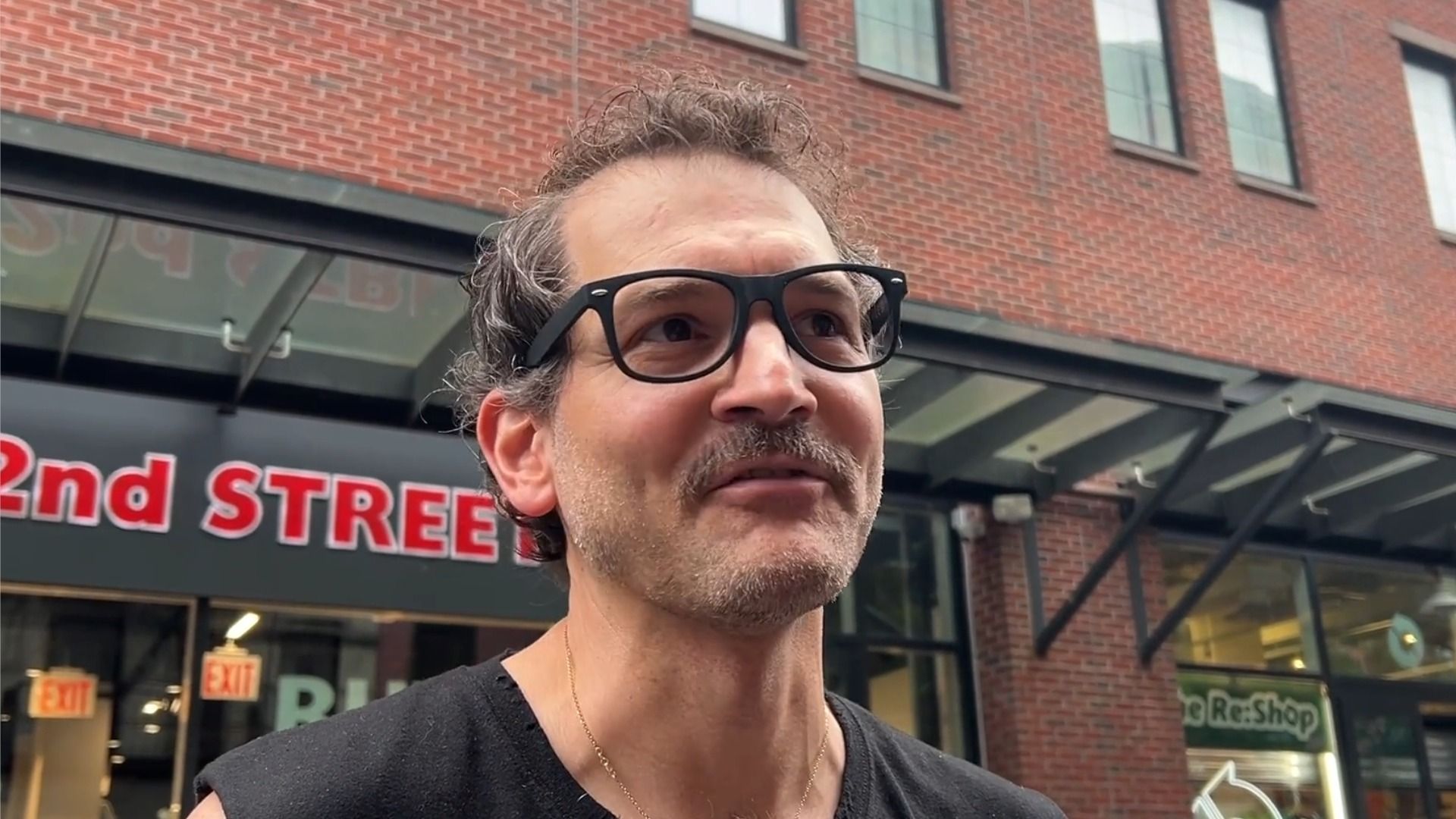 George Guntas, técnico de iluminación de The Daily Show, con camiseta negra sin mangas y gafas
