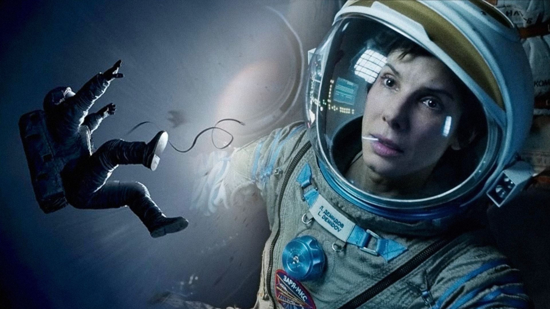 La actriz Sandra Bullock en traje espacial mirando hacia un lado con expresión seria en su rostro