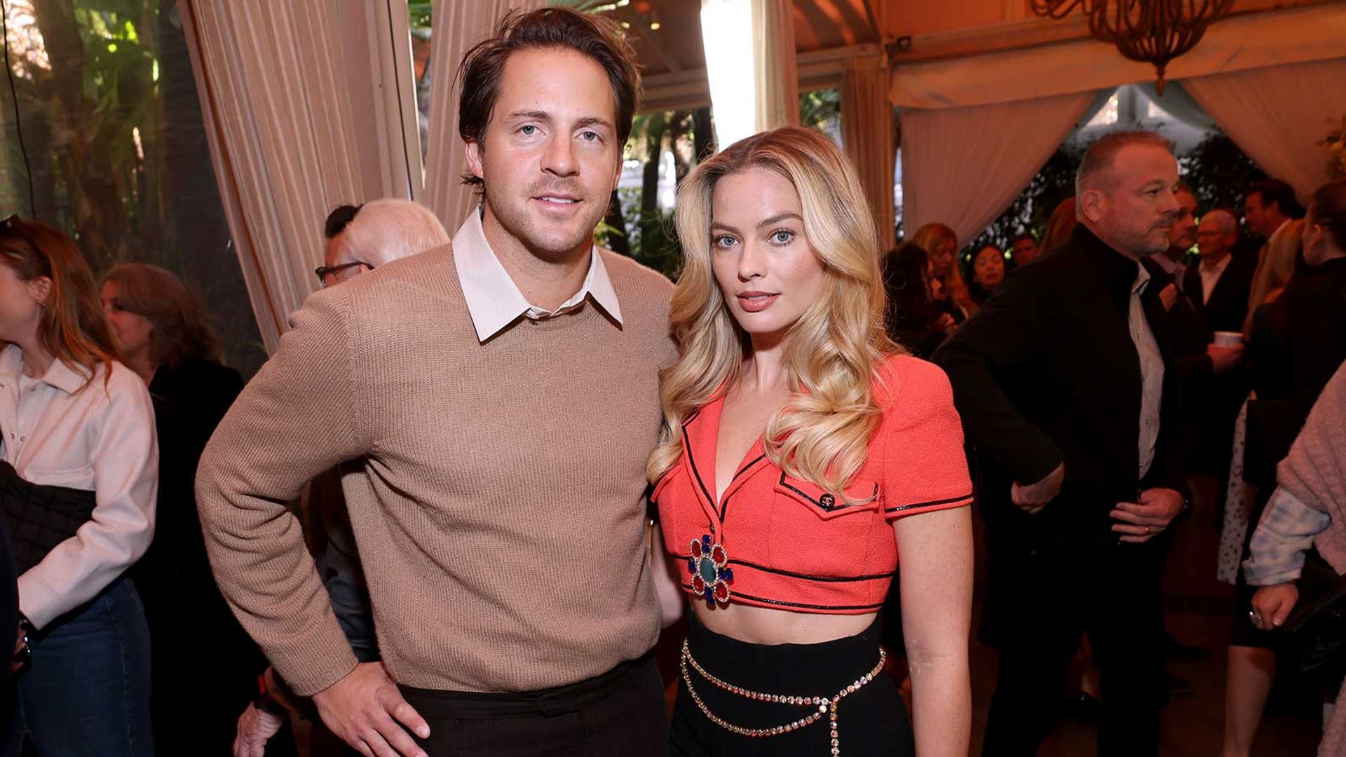 Tom Ackerley y Margot Robbie posan juntos en un evento social