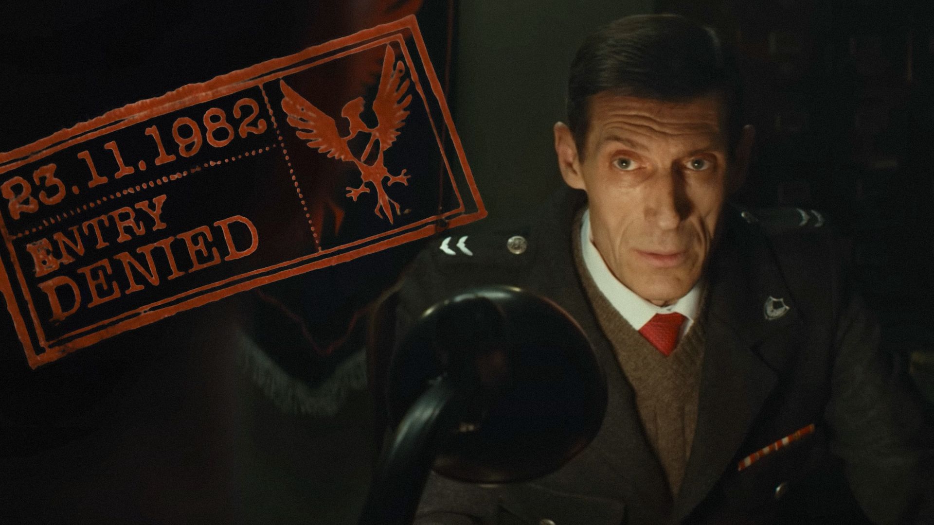El actor Igor Savochkin en uniforme de guardia fronterizo sentado en una mesa