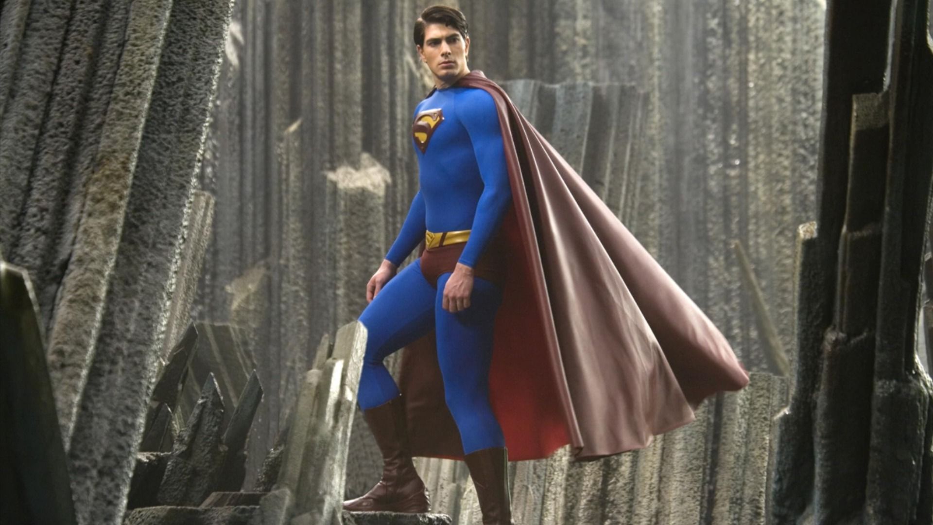 El actor Brandon Routh con un traje de superhéroe azul y rojo con la letra S en el pecho sube las escaleras