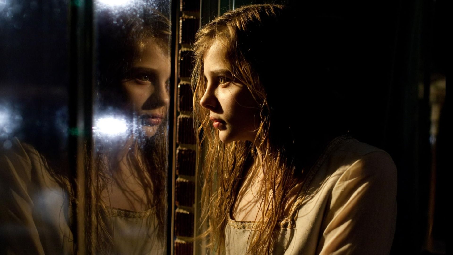 La actriz Chloë Grace Moretz mira su reflejo en la ventana