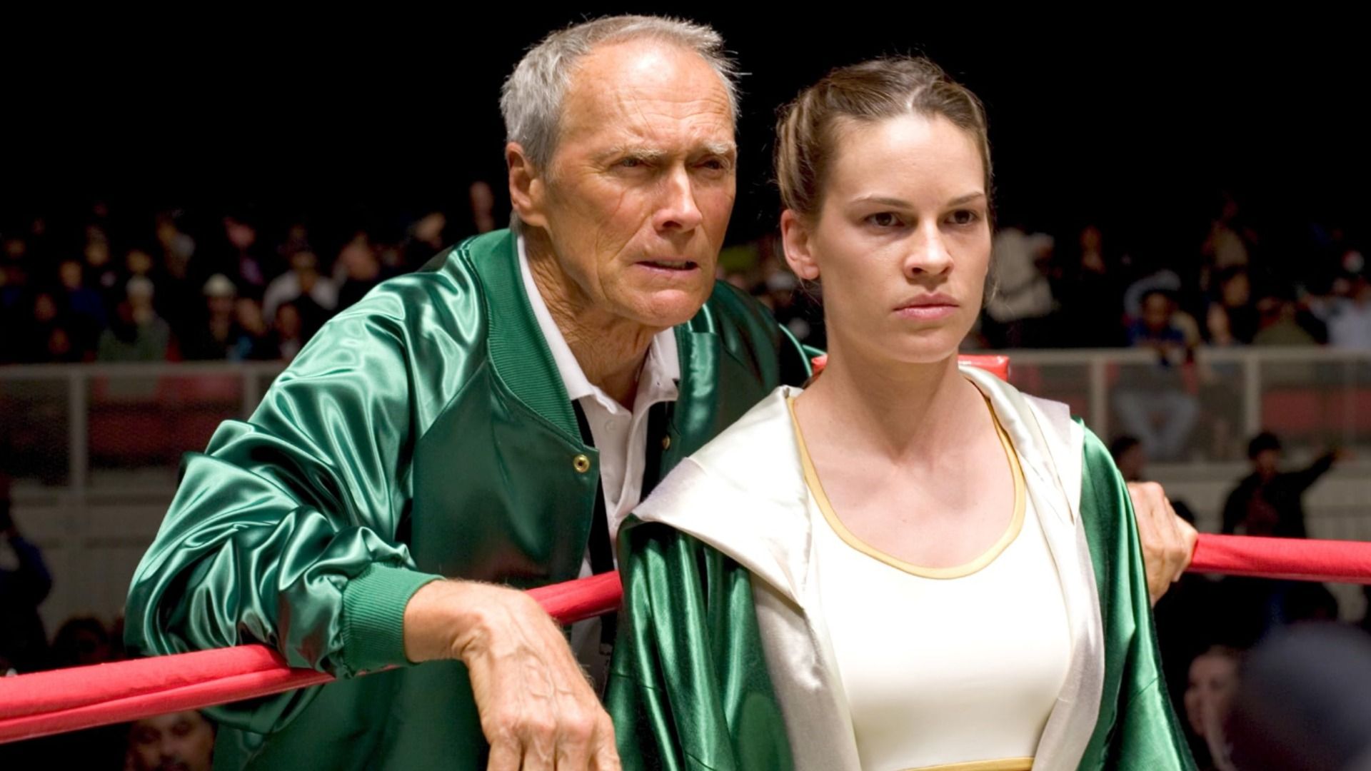 Los actores Clint Eastwood y Hilary Swank están de pie con ropa verde en un ring de boxeo