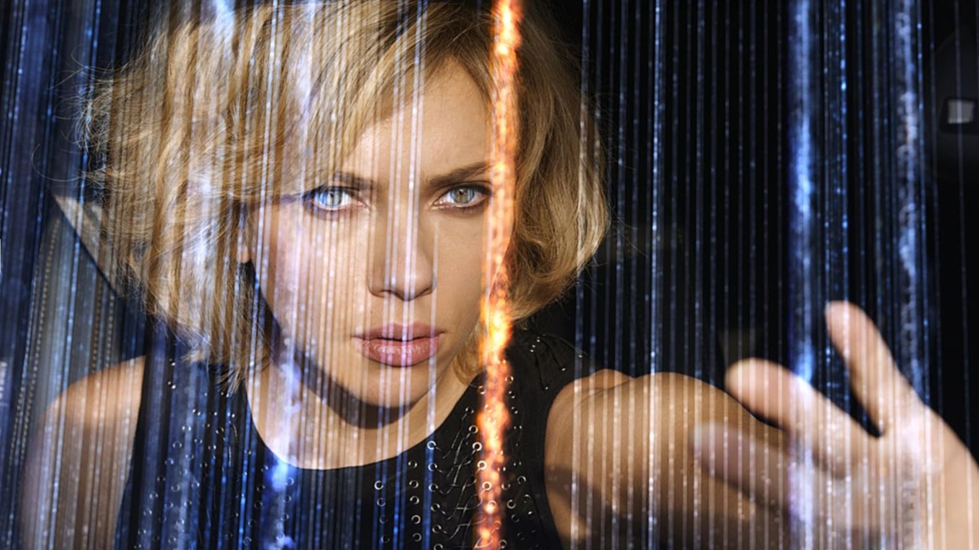 La actriz Scarlett Johansson en un vestido negro con la mano levantada entre líneas brillantes