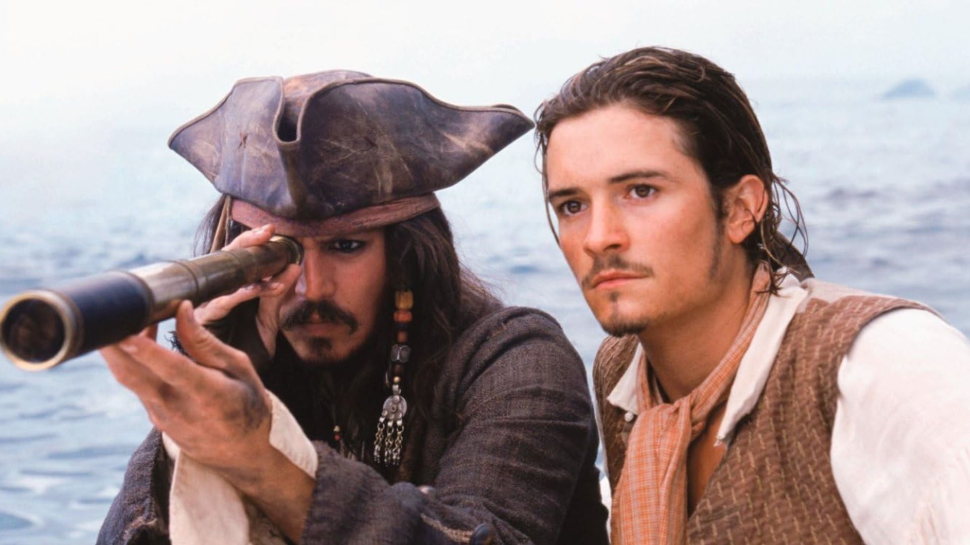 El actor Johnny Depp con sombrero de tres picos de cuero y el actor Orlando Bloom con camisa blanca