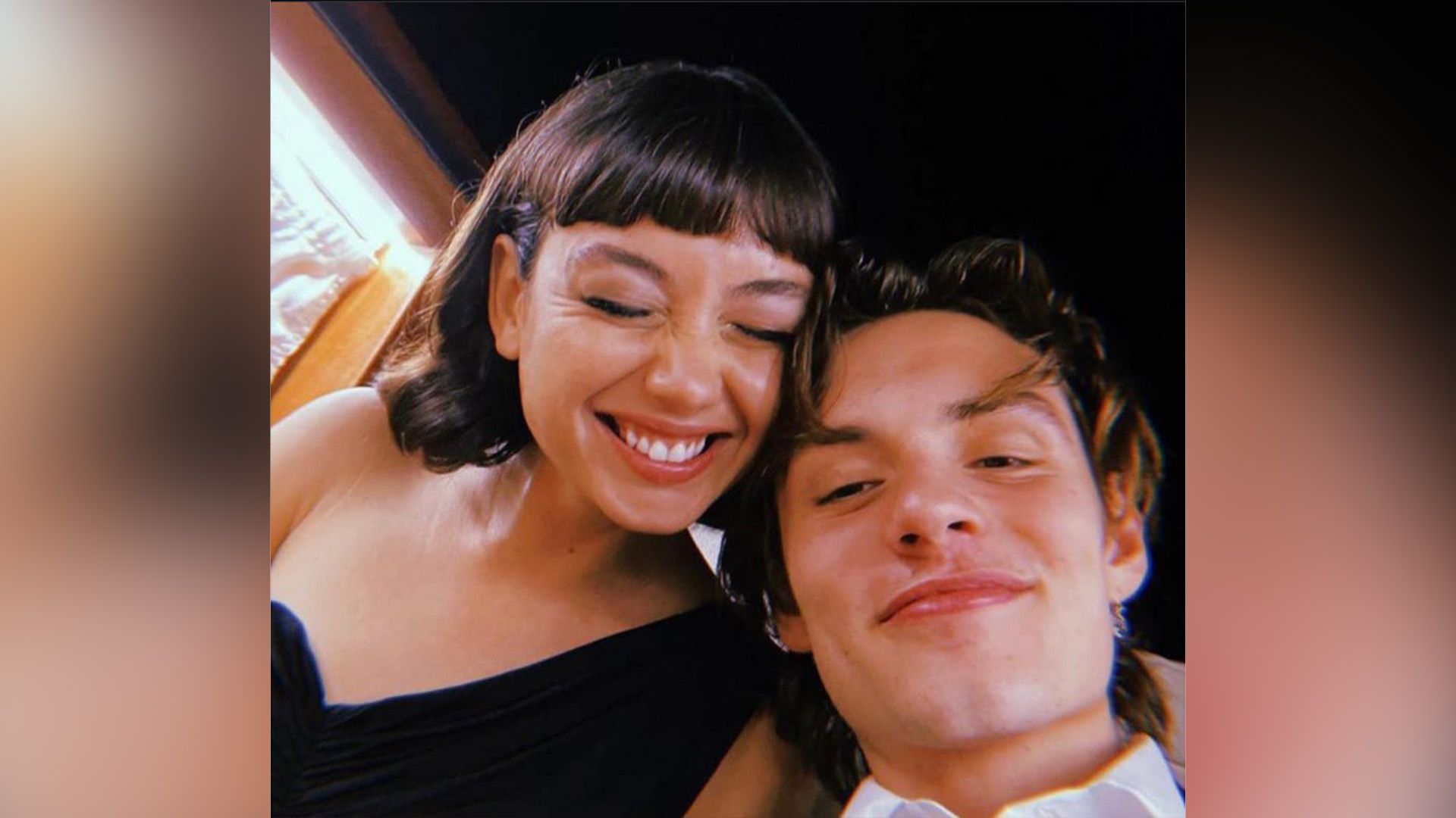 Sydney Chandler riendo y Louis Partridge sonriendo