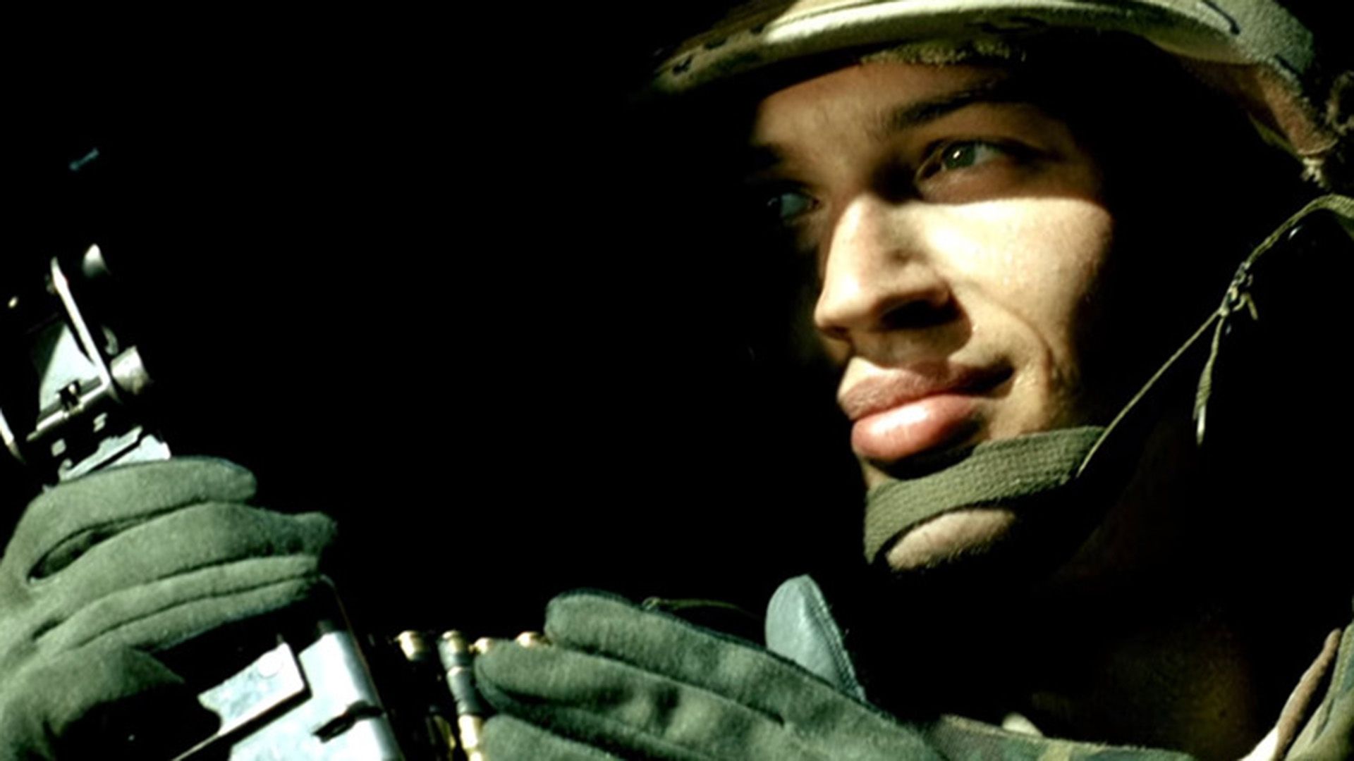 Tom Hardy en uniforme militar y casco, cara medio oculta en las sombras