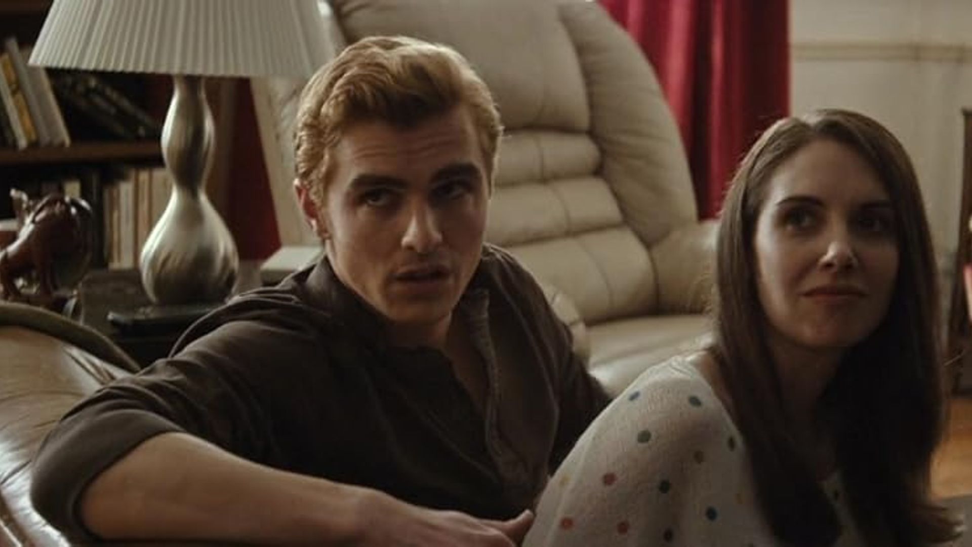Alison Brie y Dave Franco sentados en un sofá, girados hacia la cámara