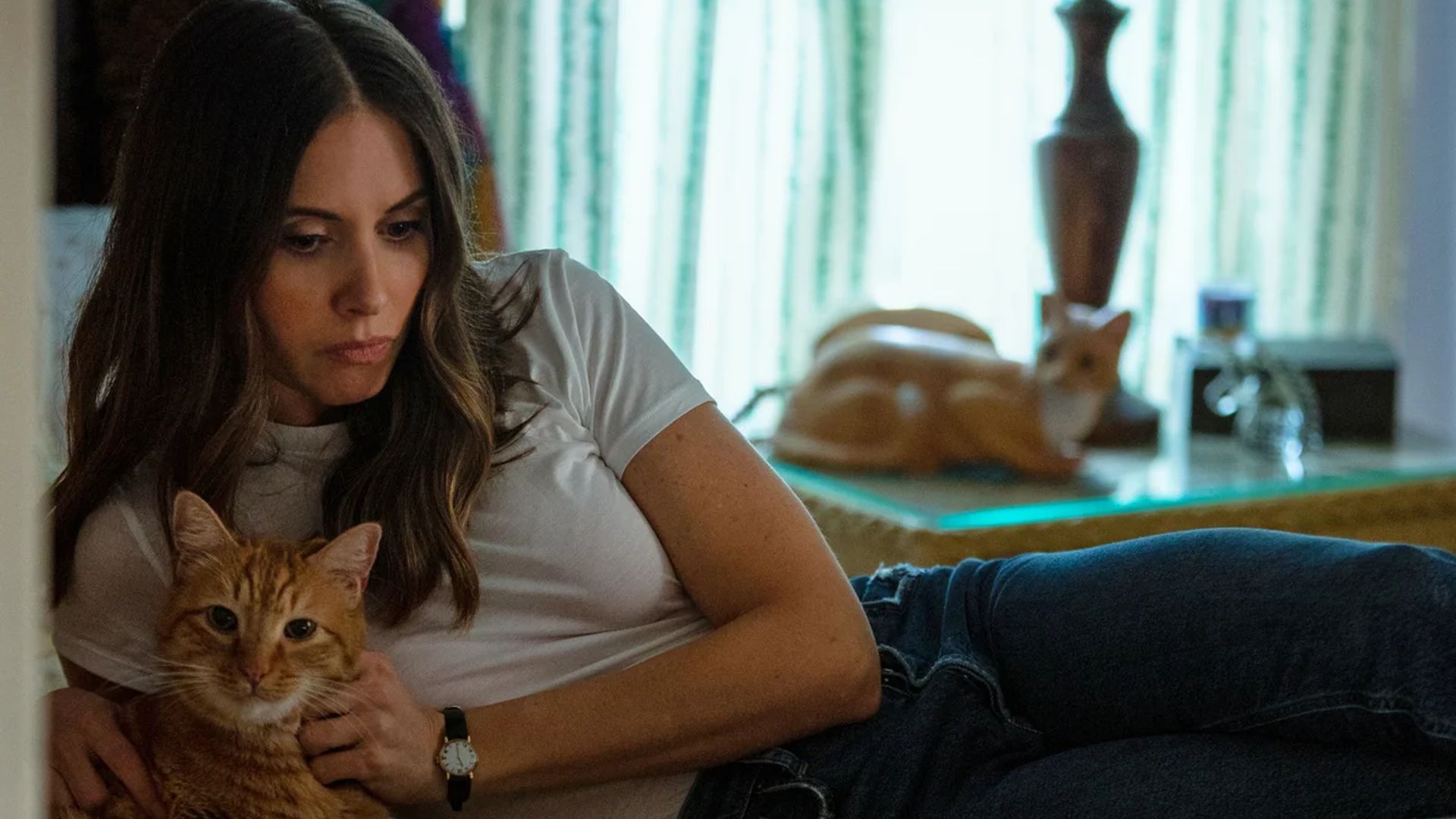 Alison Brie yace en una cama con un gato en sus brazos