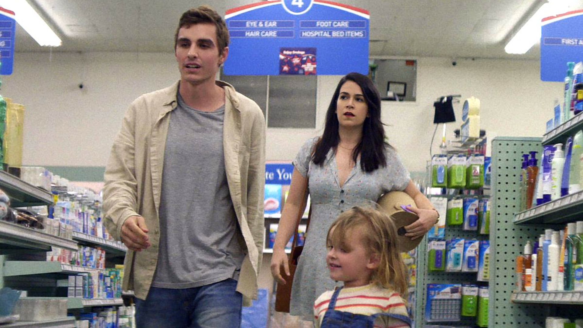 Dave Franco y Abby Jacobson caminan por un supermercado, una escena de "6 Balloons"