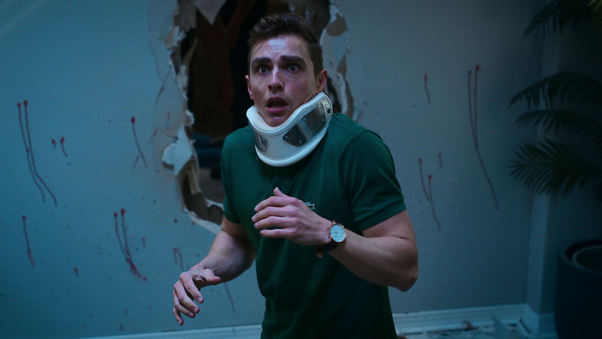 Dave Franco con un collarín ortopédico y una expresión de terror en el rostro