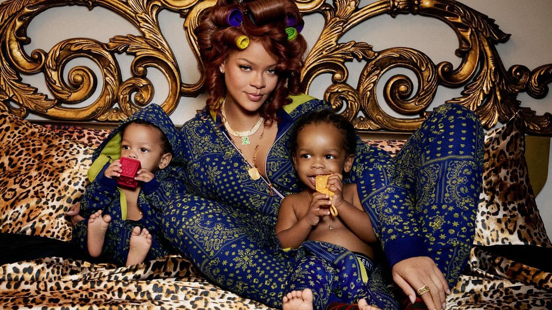 Rihanna en pijama de seda acostada en una cama abrazando a sus hijos, fotograma de sesión fotográfica