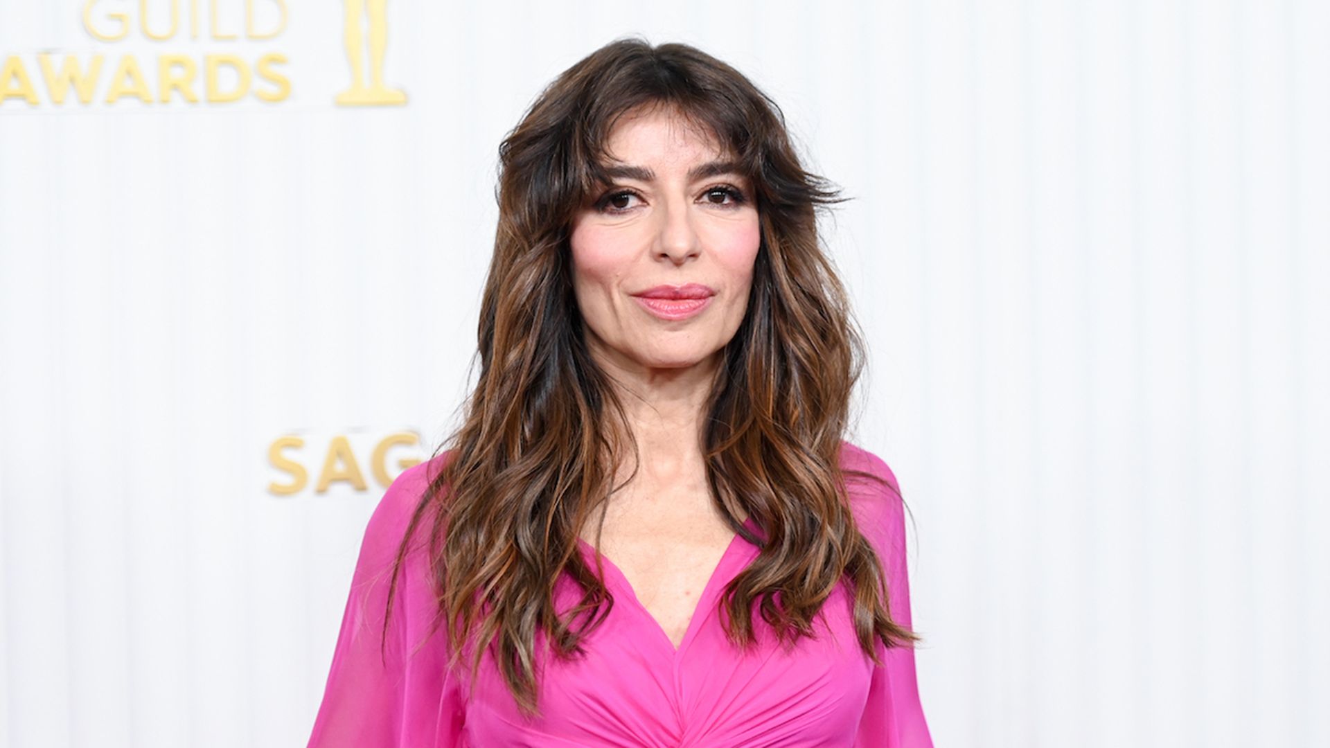 Sabrina Impacciatore con un vestido rosa sobre fondo blanco