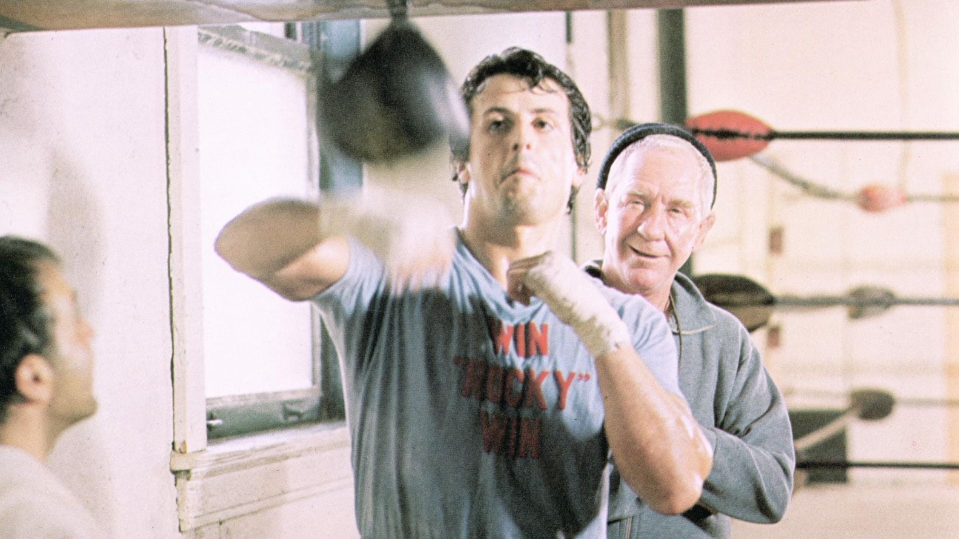 El actor Sylvester Stallone golpea un saco pequeño en un gimnasio de boxeo