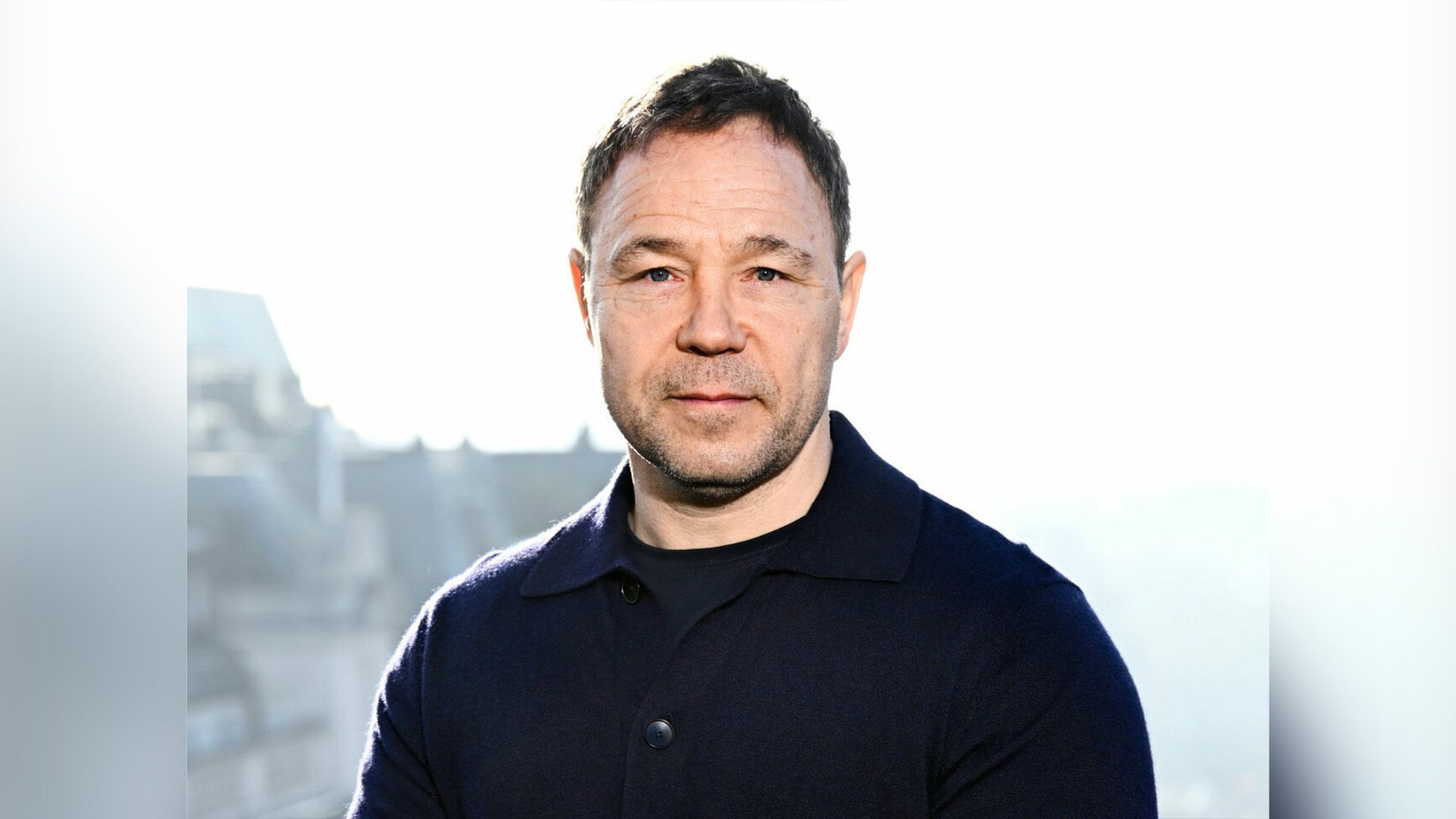 El actor Stephen Graham con un suéter negro sobre fondo blanco