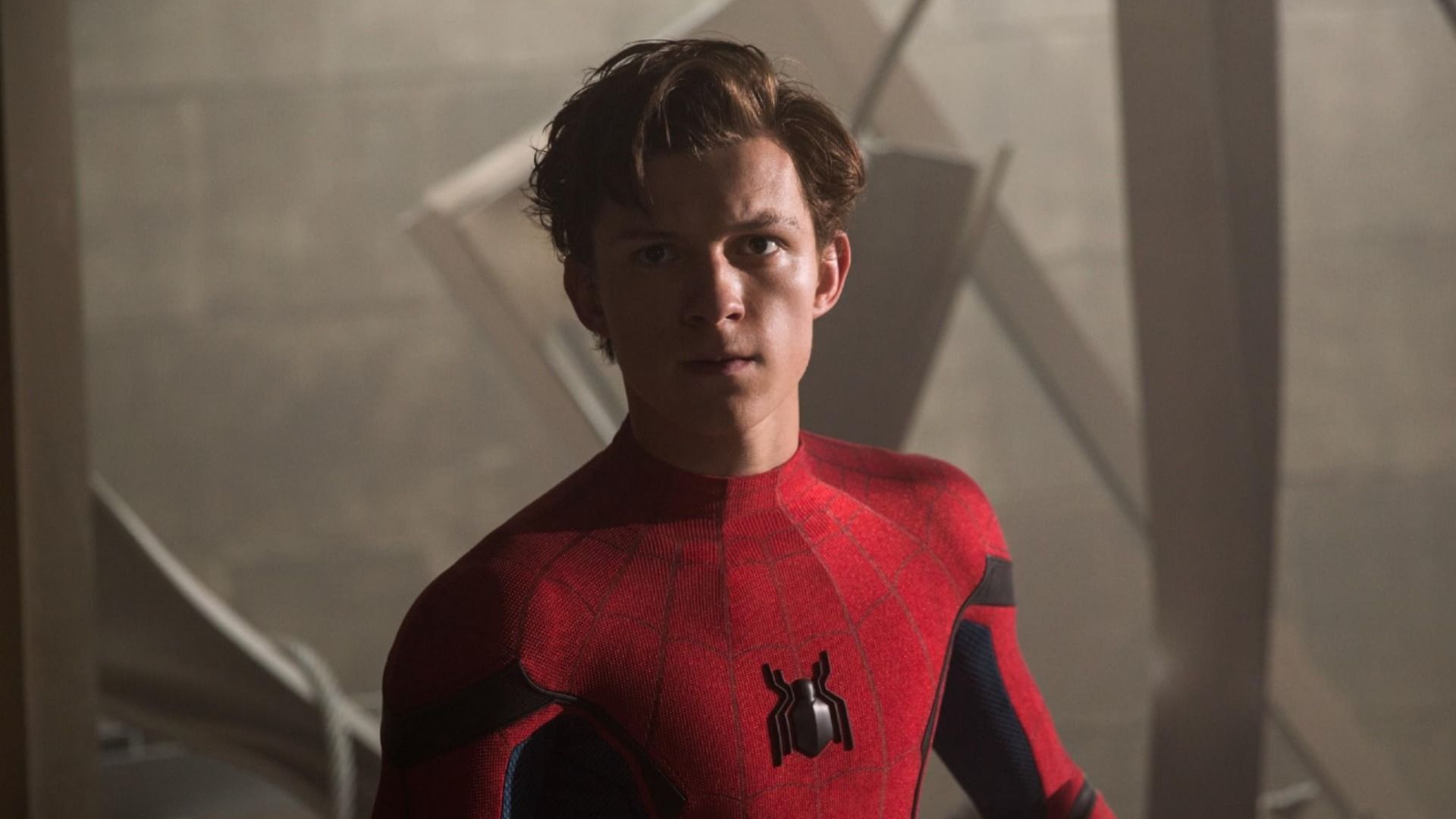 Actor Tom Holland en traje de superhéroe rojo con emblema de araña en el pecho