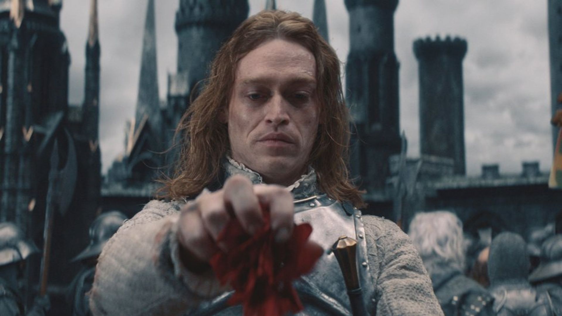 Caleb Landry Jones con maquillaje de vampiro mira hacia abajo con desprecio