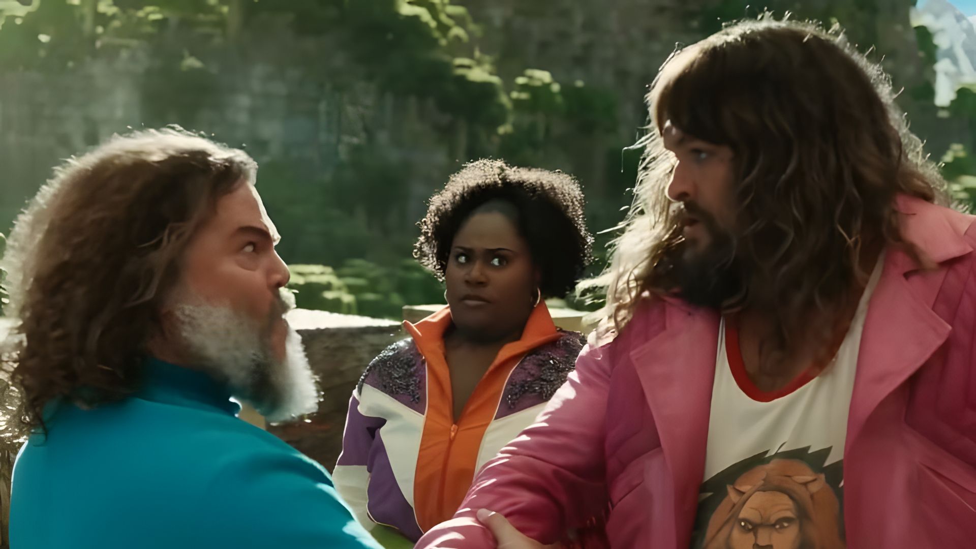 Jack Black con camiseta azul y Jason Momoa con chaqueta rosa estrechándose las manos vigorosamente